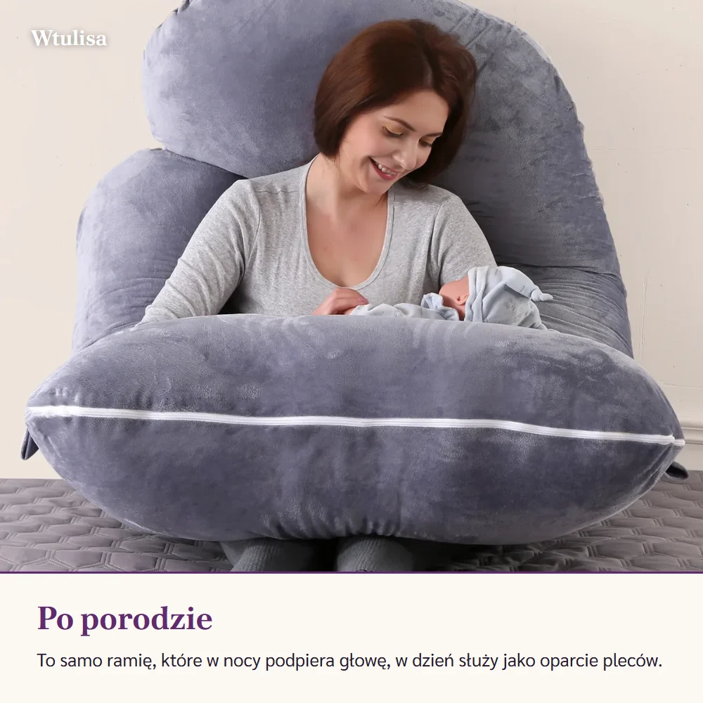Kobieta siedzi oparta o poduszkę w kształcie litery G, z niemowlęciem na ramieniu